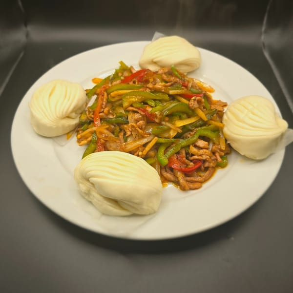 Man Chun Hong's stir-fried pork with peppers and onions, served with four steamed buns.