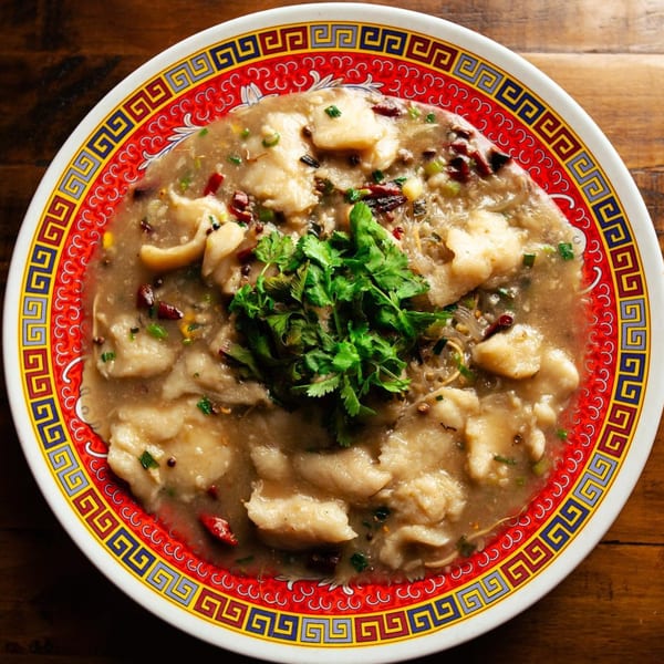 Man Chun Hong's Chinese fish dish with cilantro, chili, and noodles in a decorative bowl.